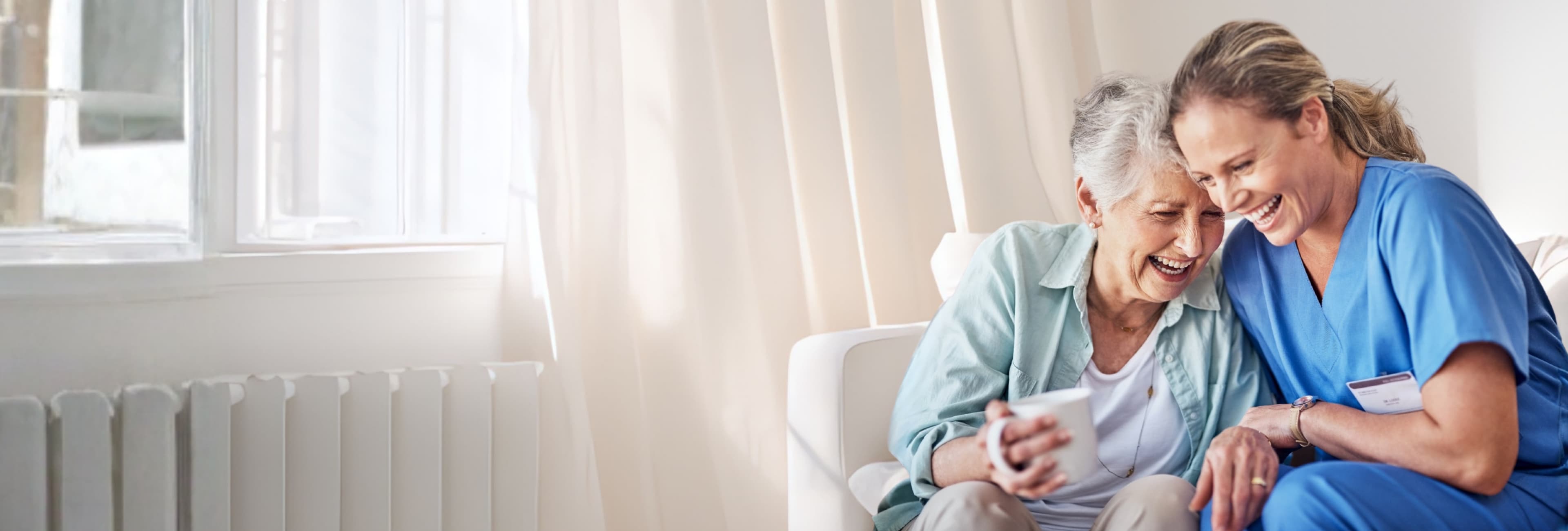 A caregiver and elderly person sharing a warm moment